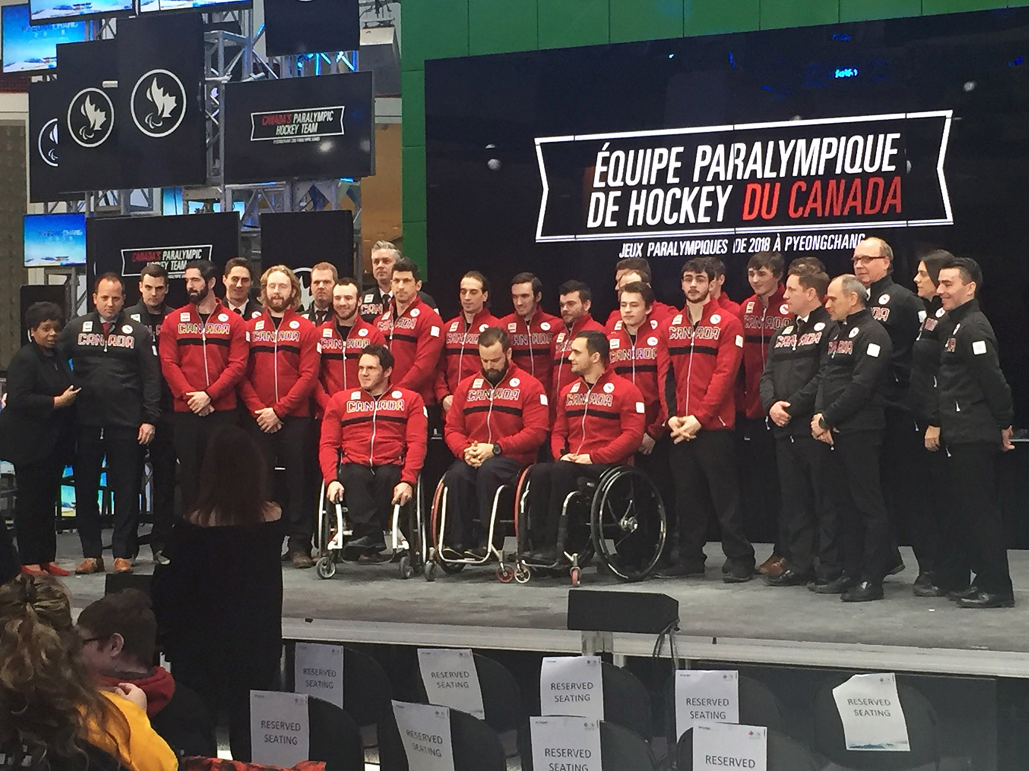 Canada's Para Hockey Team stands on stage posing for a photo. 
