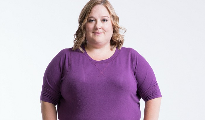 Participant Mary Beth stands facing the camera wearing a purple shirt.
