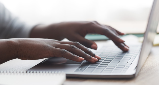 Woman typing on laptop keyboard