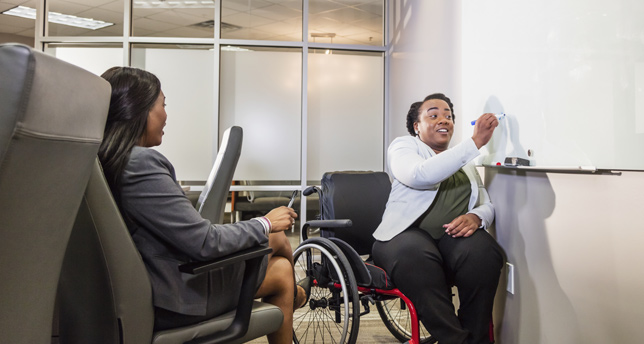 African-American women in boardroom, one in wheelchair
