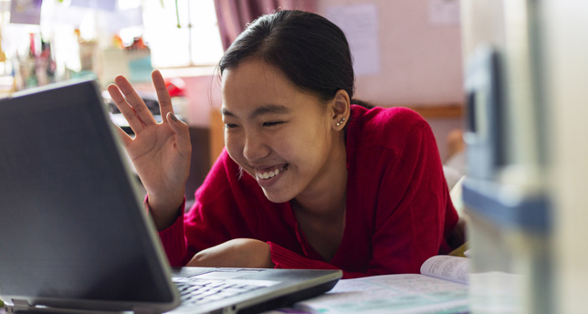 Young girl uses her laptop teleconferencing