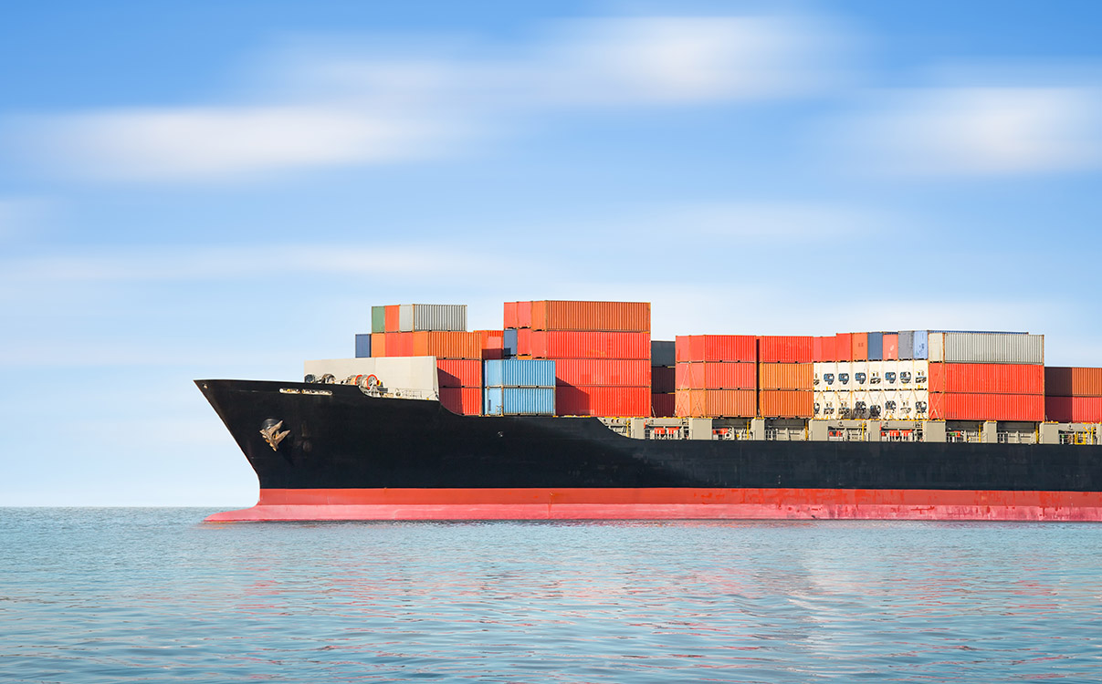 A large ship in the water filled with cargo.