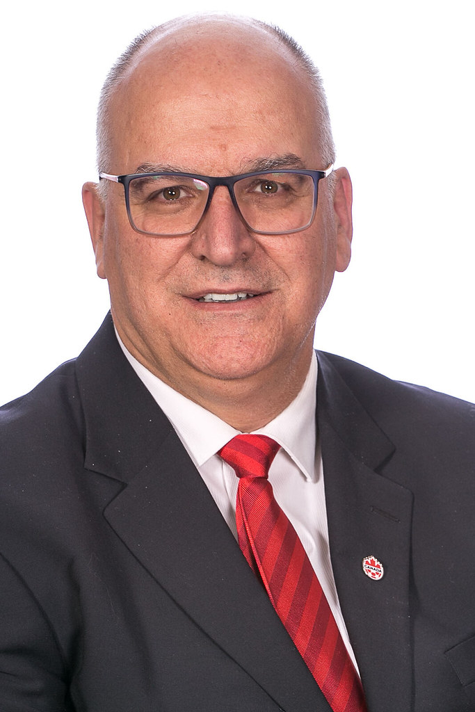 A man wearing a suit (Paul-Claude Bérubé) smiles into the camera.