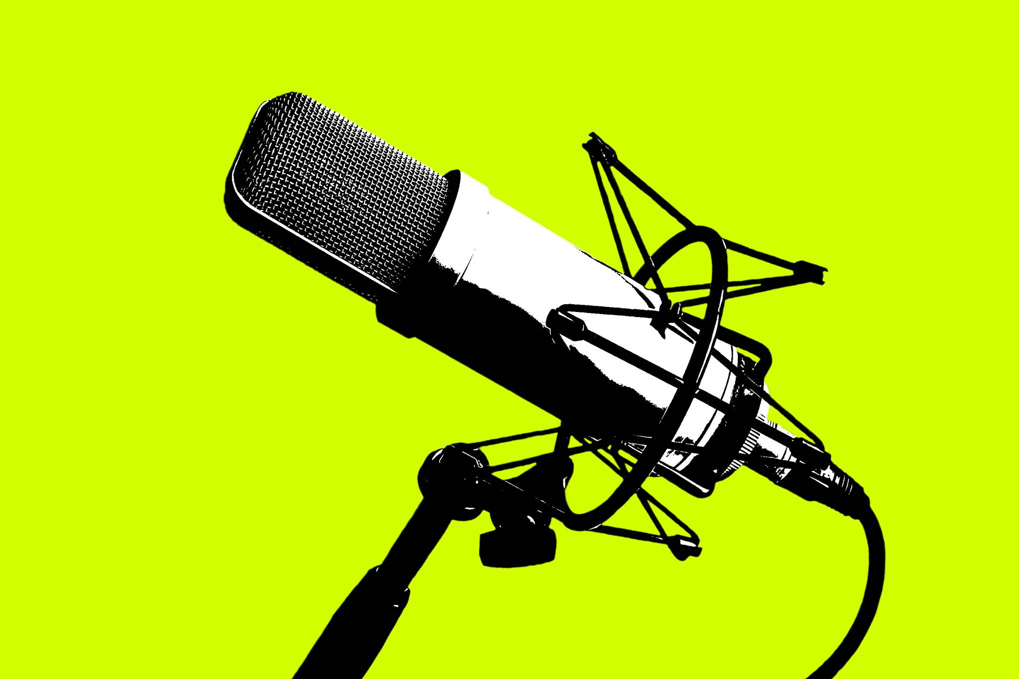 A broadcast microphone on a stand again a yellow background. 