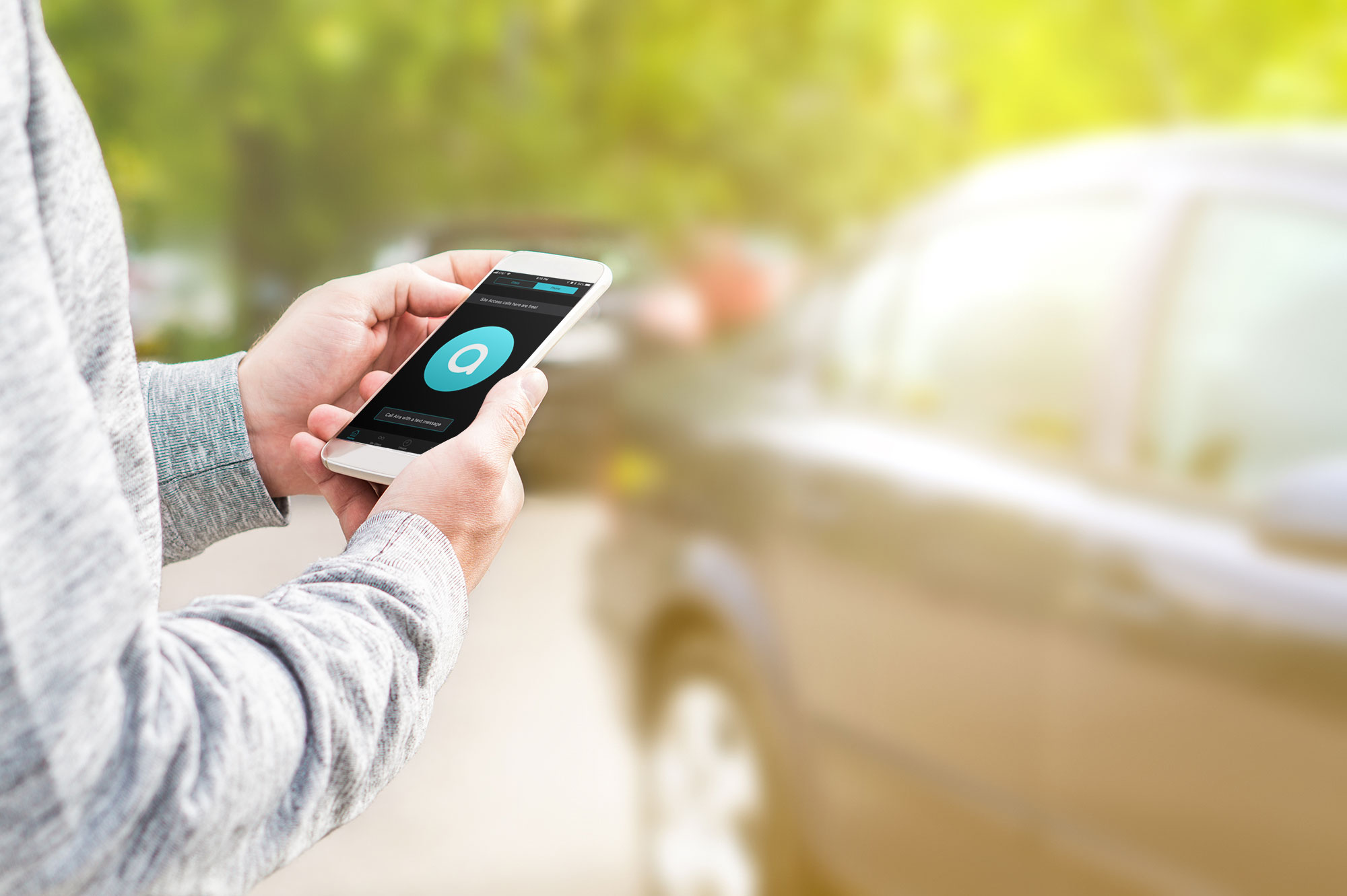 A closeup of a person's hands holding a smartphone in front of a ride-share vehicle.