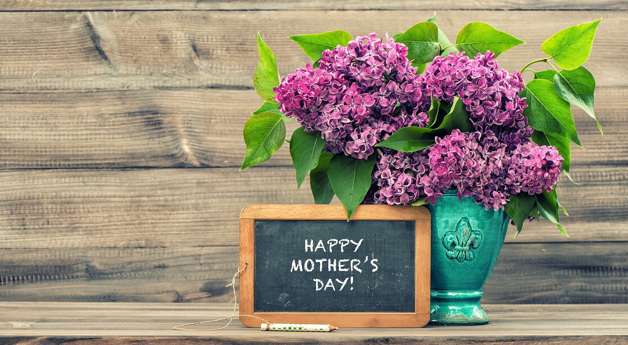 A sign and flowers that say Happy Mothers Day