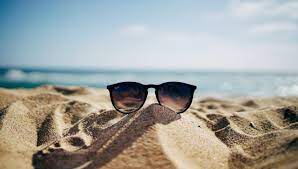 A pair of glasses in the sand at a beach