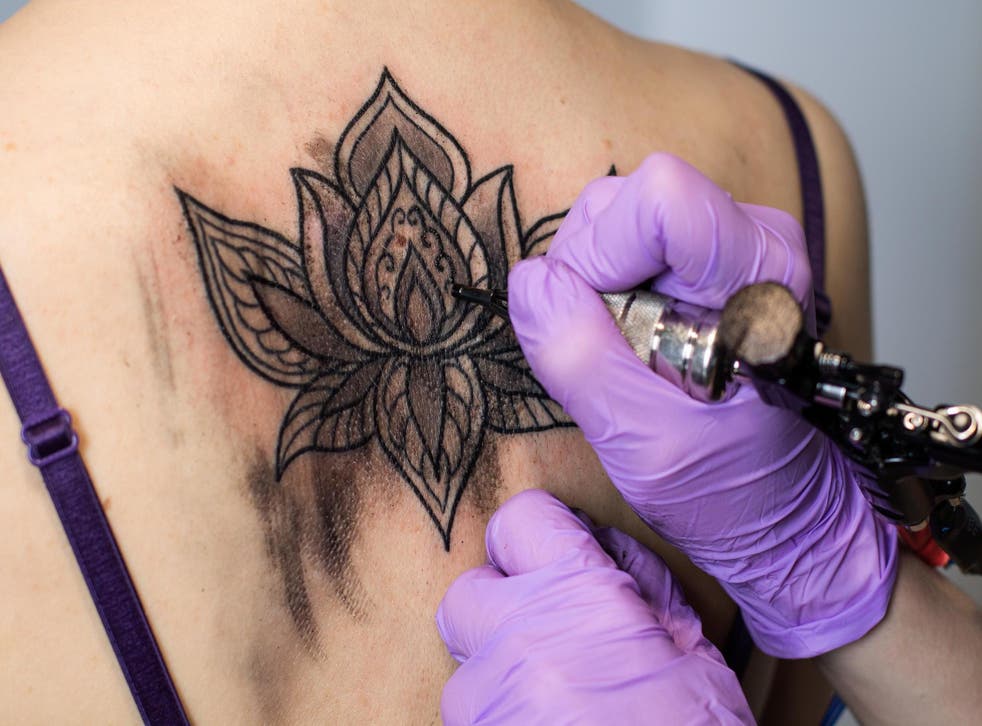 Someone getting a back tattoo