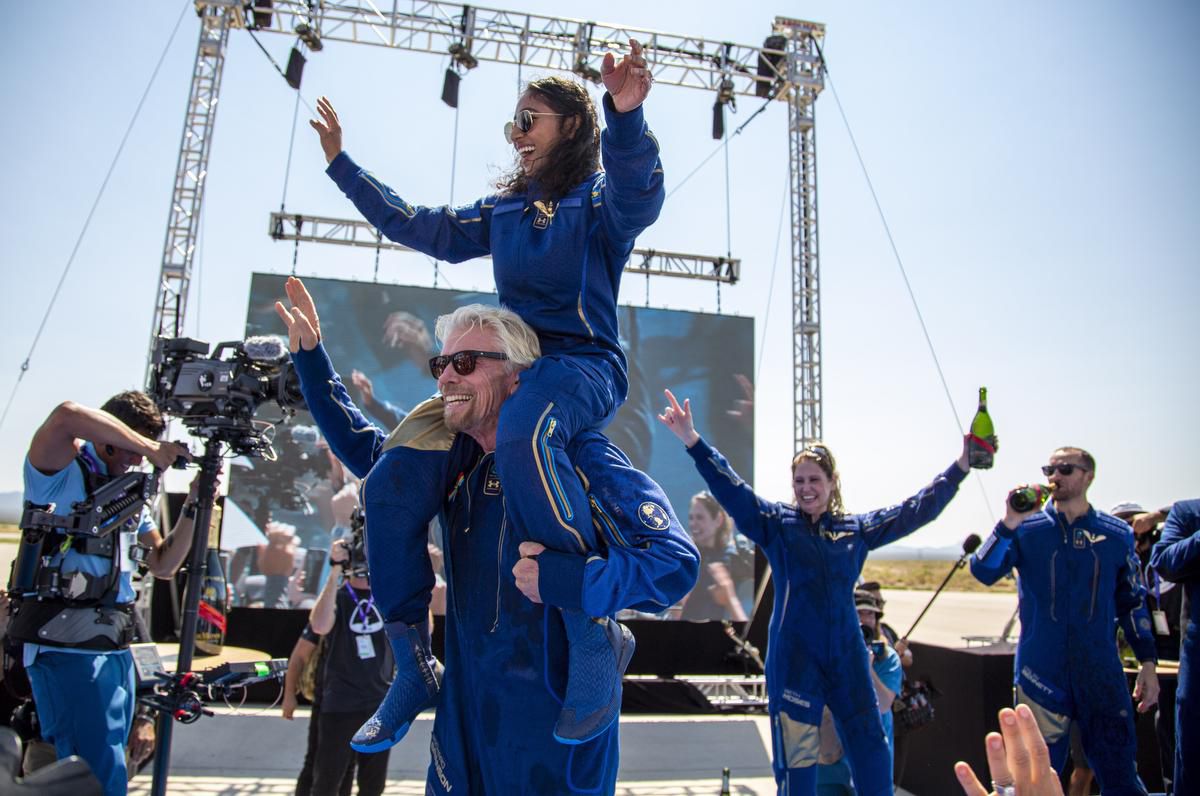 A photo of Virgin Galactic founder Richard Branson carrying a crew member Sirisha Bandla on his shoulders while celebrating their flight to space at Spaceport America near Truth or Consequences, New Mexico.
