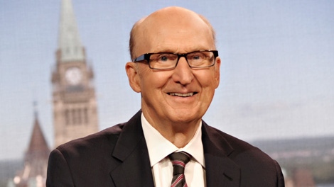 A photo of Craig Oliver smiling in a suit and wearing glasses.