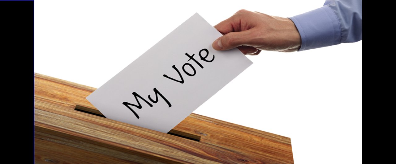 A person dropping a ballot into a box