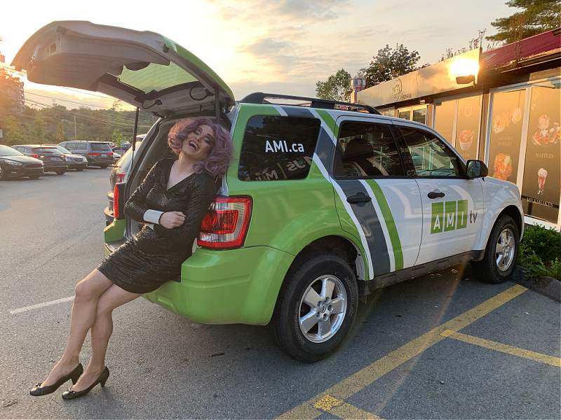 Shayla Shenanigans leans up against the AMI production vehicle.