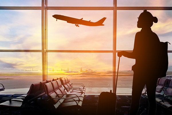 A person with luggage waiting at an airport terminal