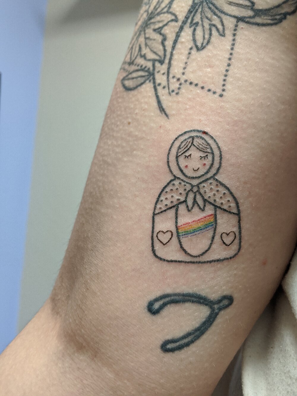 A stick and poke tattoo on an arm, by tattoo artist Hilary Wood