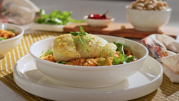 A halibut and calimari stew served in a bowl.