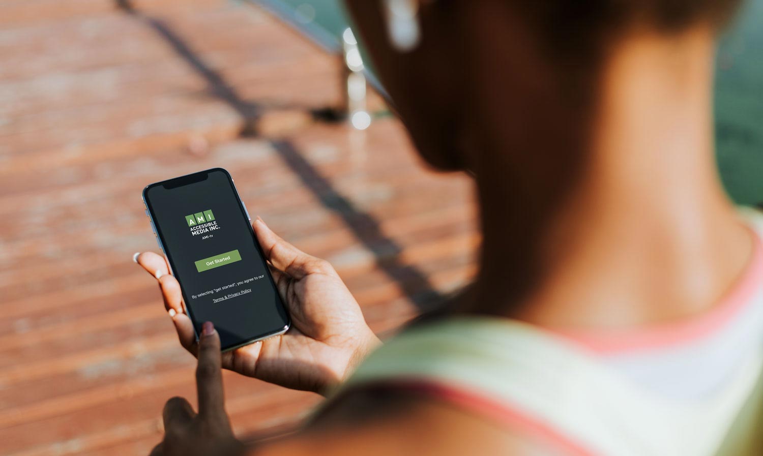 A woman watches a video using AMI-tv's iOS App on her mobile phone. 