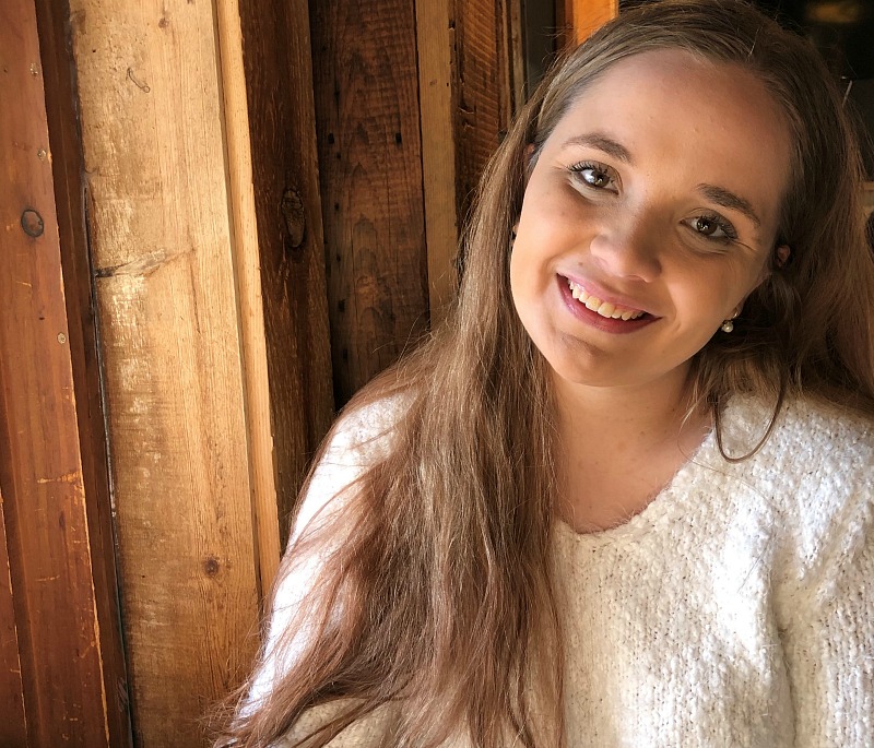 A woman smiles into the camera.