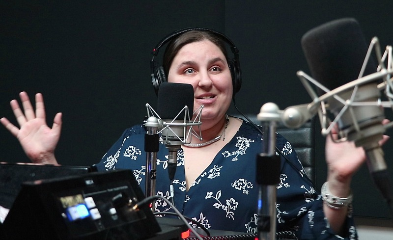 Amy Amantea smiles as she speaks into a radio microphone.