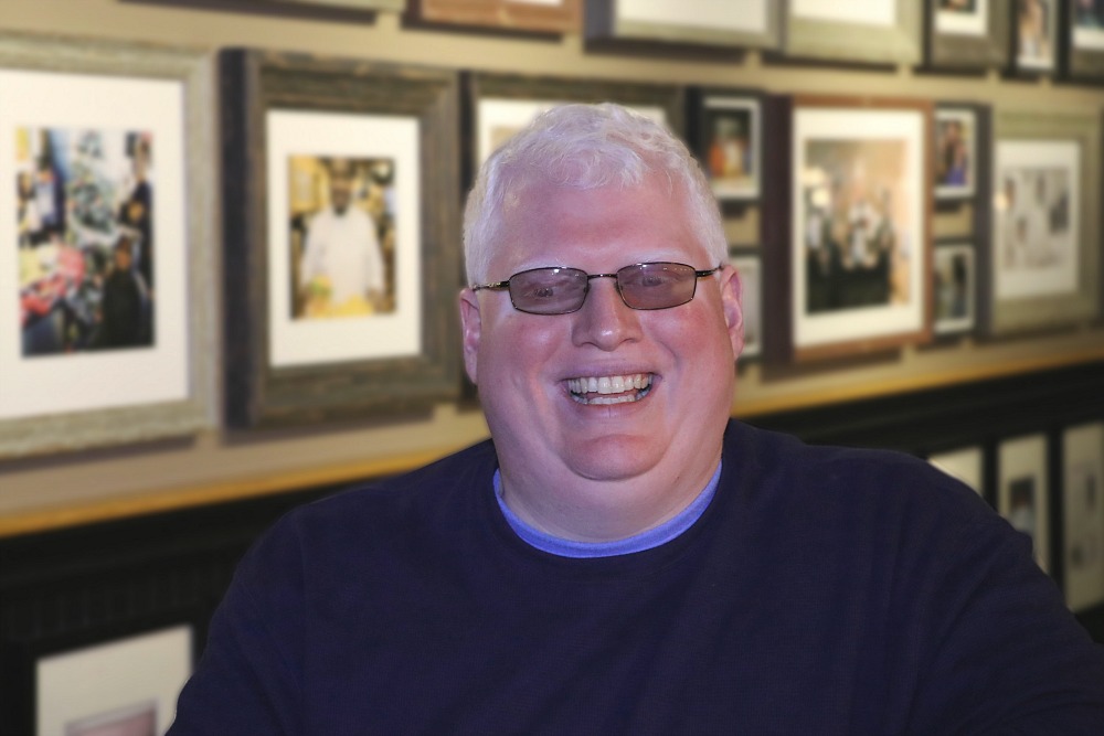 A man smiles into the camera.