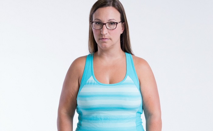 Participant Kristin stands facing the camera wearing a striped top.