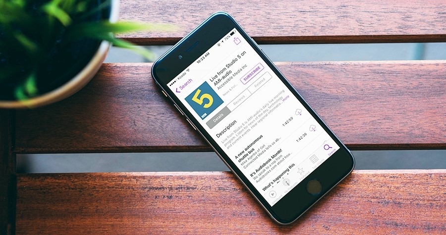 An image of an iPhone with the Live from Studio 5 podcast stream open on the iTunes Podcast App 