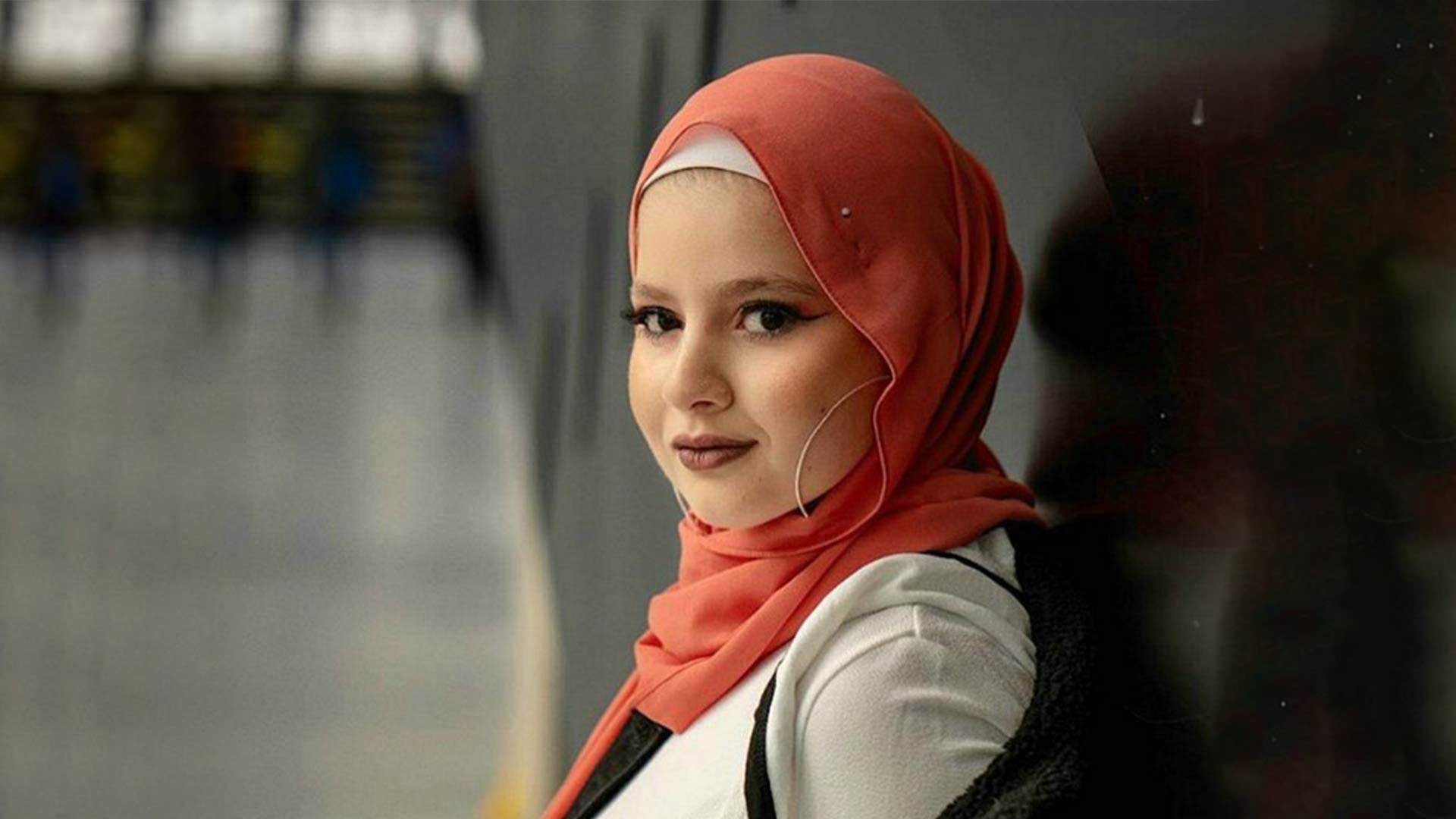 A woman smiles into the camera.