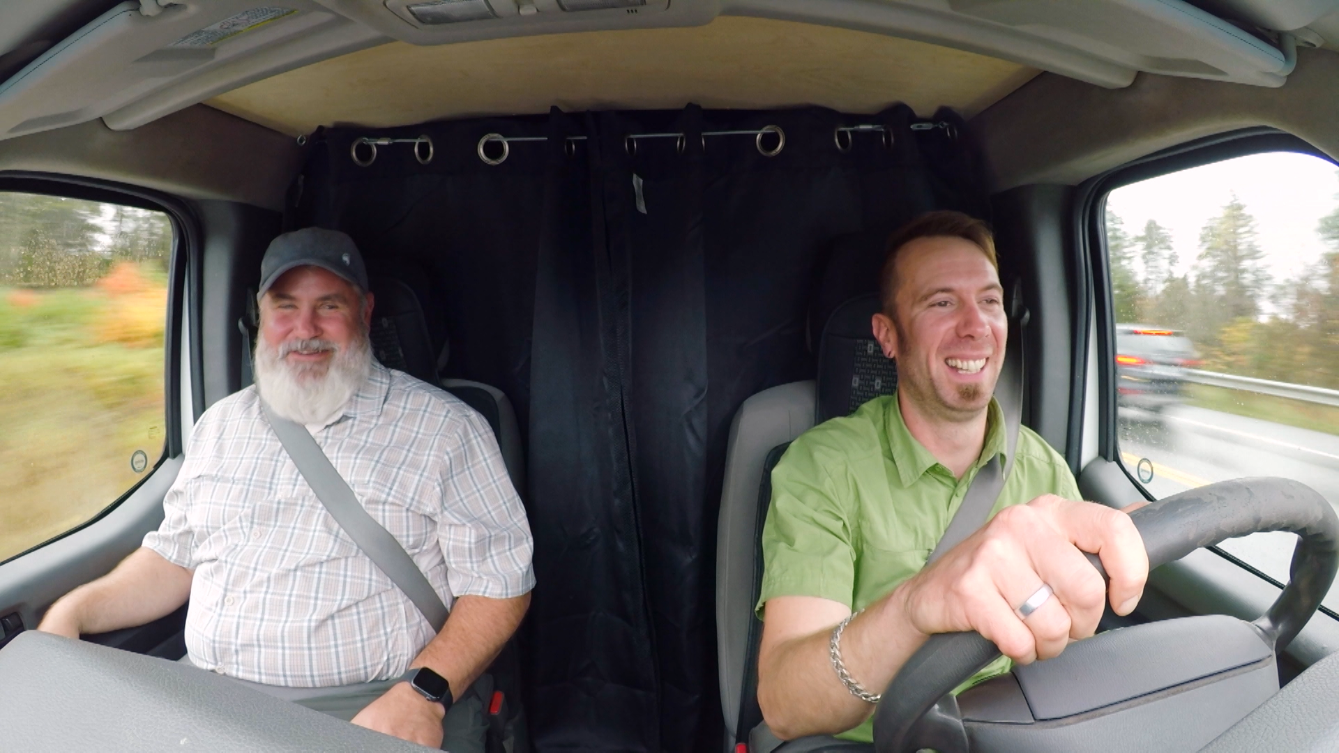 Two men ride in a van.