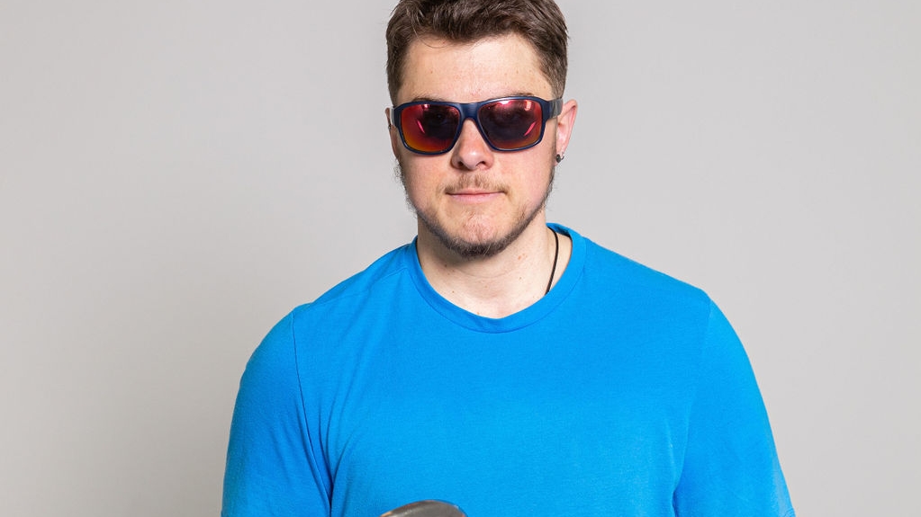 Ness, holding two discus, looks into the camera.