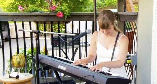 A woman sits at a keyboard.