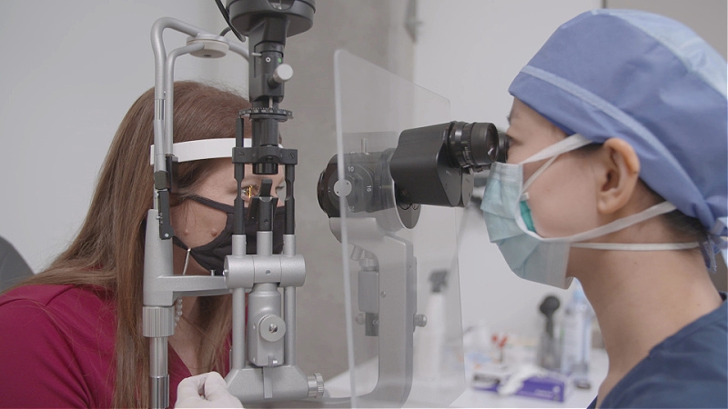 An eye doctor performs and eye exam.